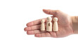 © photostockatinat - A human hand gently cradles a wooden family, symbolizing care and protection. The wooden figures represent a family unit