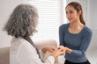 © Pichsakul - Asian adult woman giving comfort support elderly mother holding hands showing empathy understanding senior care at home living room bonding connection