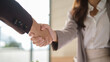 © wattana - Close-up of a handshake between two professional women, symbolizing agreement and trust.