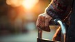 © irawan - Elderly person's wrinkled hand gripping the support bar of a mobility aid outdoors during golden hour sunlight