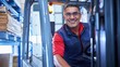 © Aliaksandr Barouski - Smiling warehouse worker operating a forklift in a busy storage facility