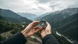 © SkNur - Close-up of hands holding a compass against panoramic mountain landscape, outdoor adventure navigation concept