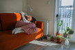 © wifesun - Young pregnant woman with toxicosis resting on a sofa under a blanket, looking unwell and fatigued from nausea and headache during early pregnancy at home