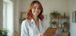 © miss irine - Smiling female therapist holds clipboard with checklist in bright office. Pro woman offers mental health support and advice. She is friendly and attentive, ready to help patients.