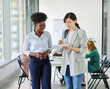© Lumos sp - Portrait of two young business woman having a meeting or presentation and seminar standing in the office. Portrait of a young business woman talking