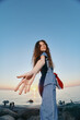 © SHOTPRIME STUDIO - lifestyle woman in modern boho-western denim street style reaches out happily at sunset by the ocean with warm film color tones and relaxed summer vibe