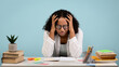 © Prostock-studio - Tired African American female student cries over her books and notebooks while preparing for a challenging college exam. She sits at a desk surrounded by study materials and office supplies.