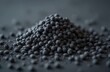 © Viktor - Heap of granular activated carbon pellets on dark surface. Macro view of porous black material, fine particles scattered around. Useful for filtration, purification, or industrial processes.