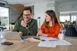 © Miljan Živković - Smiling business colleagues collaborating on design project in office
