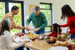© Wavebreak Media - Multi-generational family passing plates around dining table at home with terrarium centerpiece