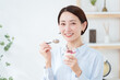 © polkadot - 朝食にヨーグルトを食べる女性