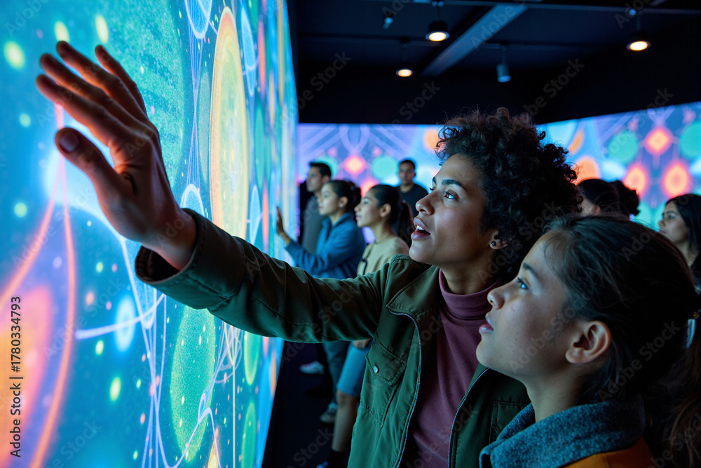 Group of engaged visitors interacting with a large, glowing interactive ...