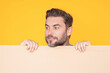 © Volodymyr - Handsome man holding empty board isolated on studio background. Guy showing blank signboard with copyspace. Idea offer. Your advertisement. Blank advertising board with empty space for text, mock up.
