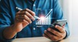 © Muhammad - Man analyzing profit and cost growth on a smartphone with a digital pen.