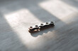 © SolaruS - Macro shot of a metal chain link on wood, bathed in sunlight. Symbolizing connection, strength, or technology.  Ideal for engineering, teamwork, or industrial concepts.