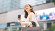 © dodotone - Single adult business asian woman holding coffee cup and shopping bag on black friday sale city people lifestyle