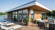 © vadosloginov - Modern lakeside cabin offers relaxing views and serene environment for summer gatherings and leisure activities on a bright day