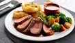 © Bendik - juicy roast beef slices served on white plate with yorkshire pudding roasted vegetables and herbs mouth watering sunday dinner with delicious gravy