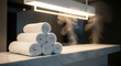 © capslock - Luxurious spa setting with a stack of clean white rolled towels and relaxing steam on a counter