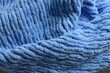 © Anastasiia Harbar - Macro shot of a soft blue knitted blanket showing detailed fabric pattern and cozy texture. Warm textile background for design or decoration.