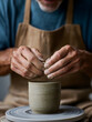 © CatNap Studio - Hands shaping clay pot spinning wheel detail shows creative focus. craftsman enjoys making something beautiful