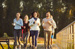 © Studio Romantic - Sporty happy group of friends running together along outdoor track exercising for fitness activity showing health and friendship, shared enjoyment, jogging sport team, pace, movement work out