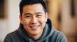 © Kitta Studio - Smiling Young Man in Casual Gray Hoodie with Bright Expression