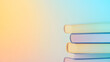 © SIMANG - A stack of books with colorful covers placed on a soft gradient background, representing education and knowledge.