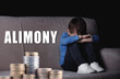 © New Africa - Sad little boy on sofa in darkness and stacked coins. Alimony, money support for child after divorce