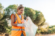 © ADDICTIVE STOCK - Volunteer cleaning roadside litter by the forest