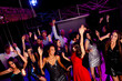 © deagreez - Party night at neon club dancers groove together as crowd cheers music lights sparkle and friends celebrate together