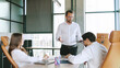 © Марина - Team members engage in a business meeting in a contemporary office space, discussing strategies and sharing ideas while seated at a conference table.