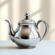 © Jdgkxbnc - shiny polished silver teapot with curved handle and lid reflecting window light on a smooth surface