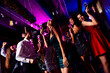 © deagreez - Energetic party crowd in a neon club dancing under vibrant lights celebrating a night of friends music and fashion