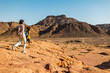 © zhukovvvlad - A mother and child on a hike. A boy with a map and a backpack walks next to his mother. Family trekking. Timna National Park. The child is actively spending time.