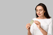 © Pixel-Shot - Pretty young woman with pills on grey background