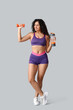 © Pixel-Shot - Sporty young African-American female coach with dumbbell and water bottle on white background