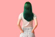 © Pixel-Shot - Young woman with green hair on pink background, back view