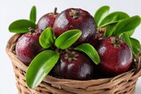 Harvested Kokum: Fresh Garcinia Indica in Cane Basket with Lush Leaves, Celebrating Ayurvedic Nutrition from Coastal Asia