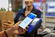 © Rido - Close up of mobile payment at checkout