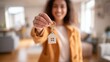 © Khawla - Happy Woman Holding New House Keys in Cozy Living Room. realtor selling apartment, offering to client, real estate agent, mortgage or rent