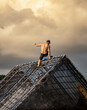 © sirbouman - Male athlete in tights and shirtless climbing an obstacle course during an outdoor endurance race against a spectacular cloudy sky.