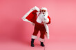 © deagreez - Santa in red suit with white fur cape sings into a microphone on a pink studio background for a festive holiday moment