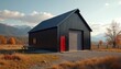 © miss irine - Modern black steel building with red door sits in rural landscape. Mountains and autumn trees surround the structure. Outdoor picnic table is visible.