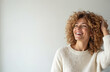 © miss irine - Young woman with curly hair laughs heartily. She has a bright smile and touches her head gently. Her expression is full of joy and positivity. The background is plain white.