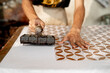 © Vlafy Studio - close up of batik maker pressing copper stamp ( BATIK CAP ) dipped in hot wax onto fabric, capturing manual craftsmanship and traditional textile printing in Pekalongan, Indonesia.
