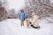 © StockMediaSeller - Elderly woman and her adult daughter enjoying a snowy day outdoors with their Golden Retriever.
