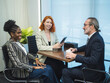 © Singh - Diverse group of three professional engaged in business meeting in modern office setting. with one person holding tablet and coffee cup. background feature large window indoor plant, creating bright
