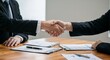 © Pavel Semin - Business partners shaking hands over documents on wooden table