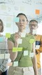 © volha_r - Professional team brainstorming, sharing strategy on glass whiteboard with colorful sticky notes, working collaboratively in bright office space